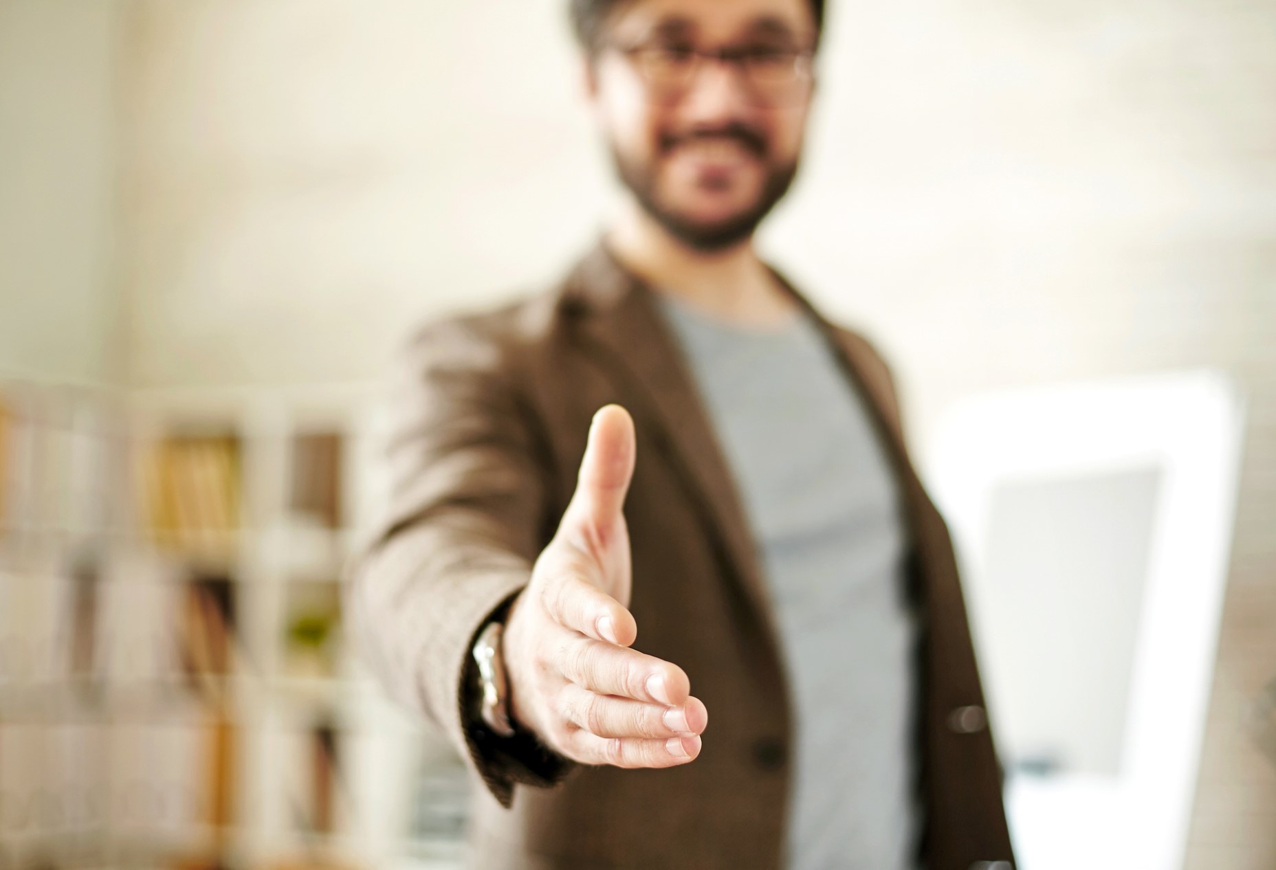 Smiling man with an outstretched hand ready for a handshake