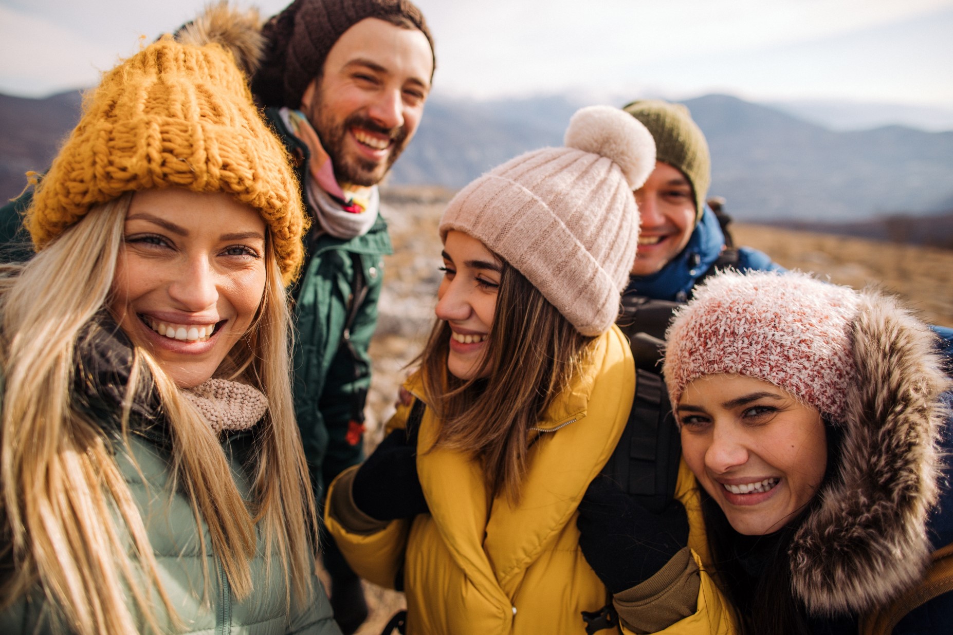 Friendly group of people all wearing knit hats of different colors and styles
