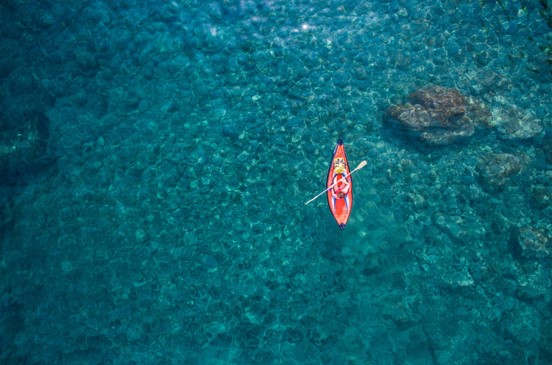 Kayaker in the middle of the bright blue gorgeous ocean