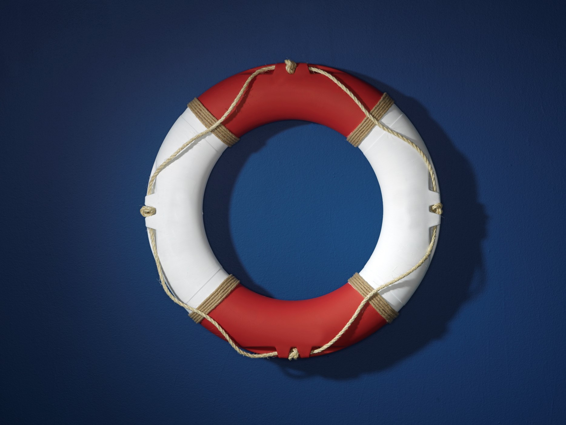 Red and white round life saver / life preserver on a dark navy blue background